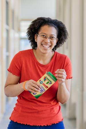 Laurel Bacote laughing while holding colored pencils