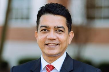 A South Asian man smiles