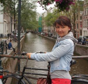 Jenya standing by the river and smiling