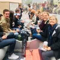 Students sitting in life boat at exhibit