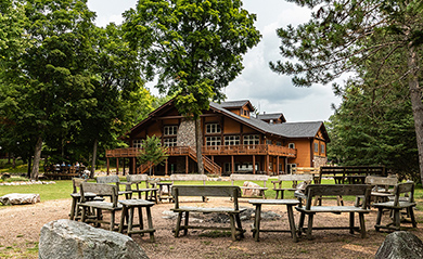 A big house and some chairs in the woods