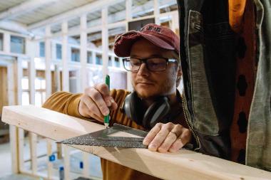 student measures wood board