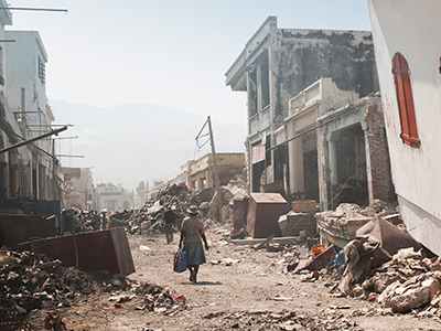 people walking through earthquake rubble