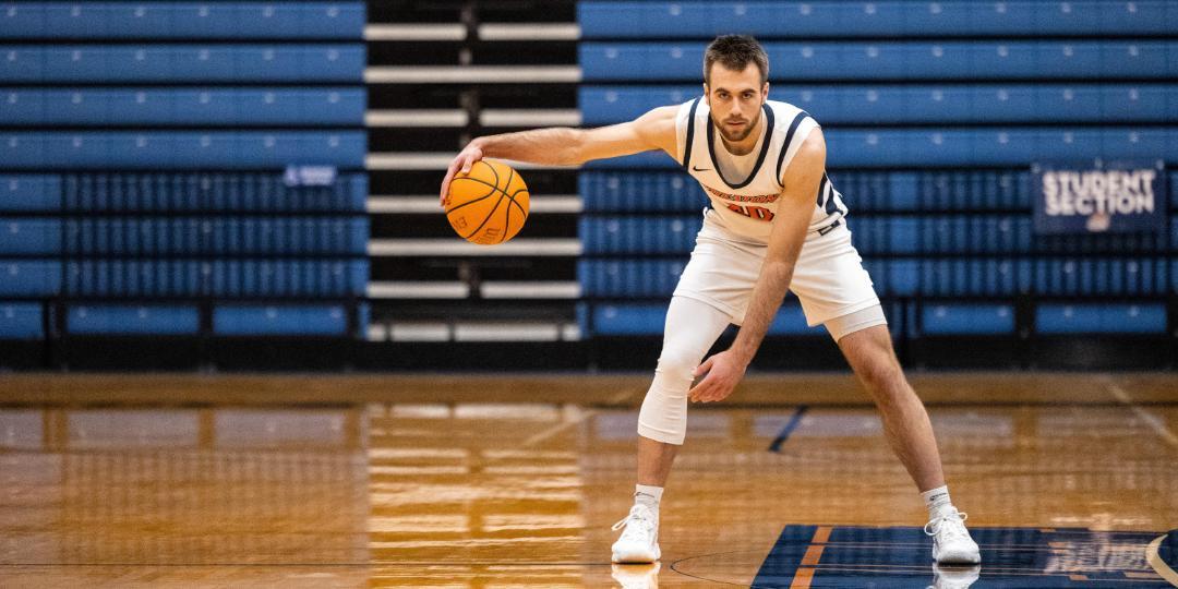 Wheaton College IL Athlete Soren Richardson dribbles on the basketball court