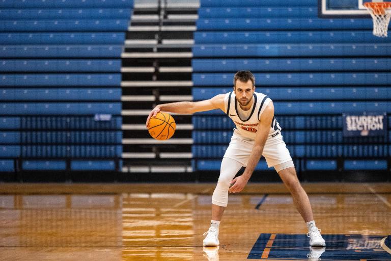 Wheaton College IL Athlete Soren Richardson dribbles on the basketball court