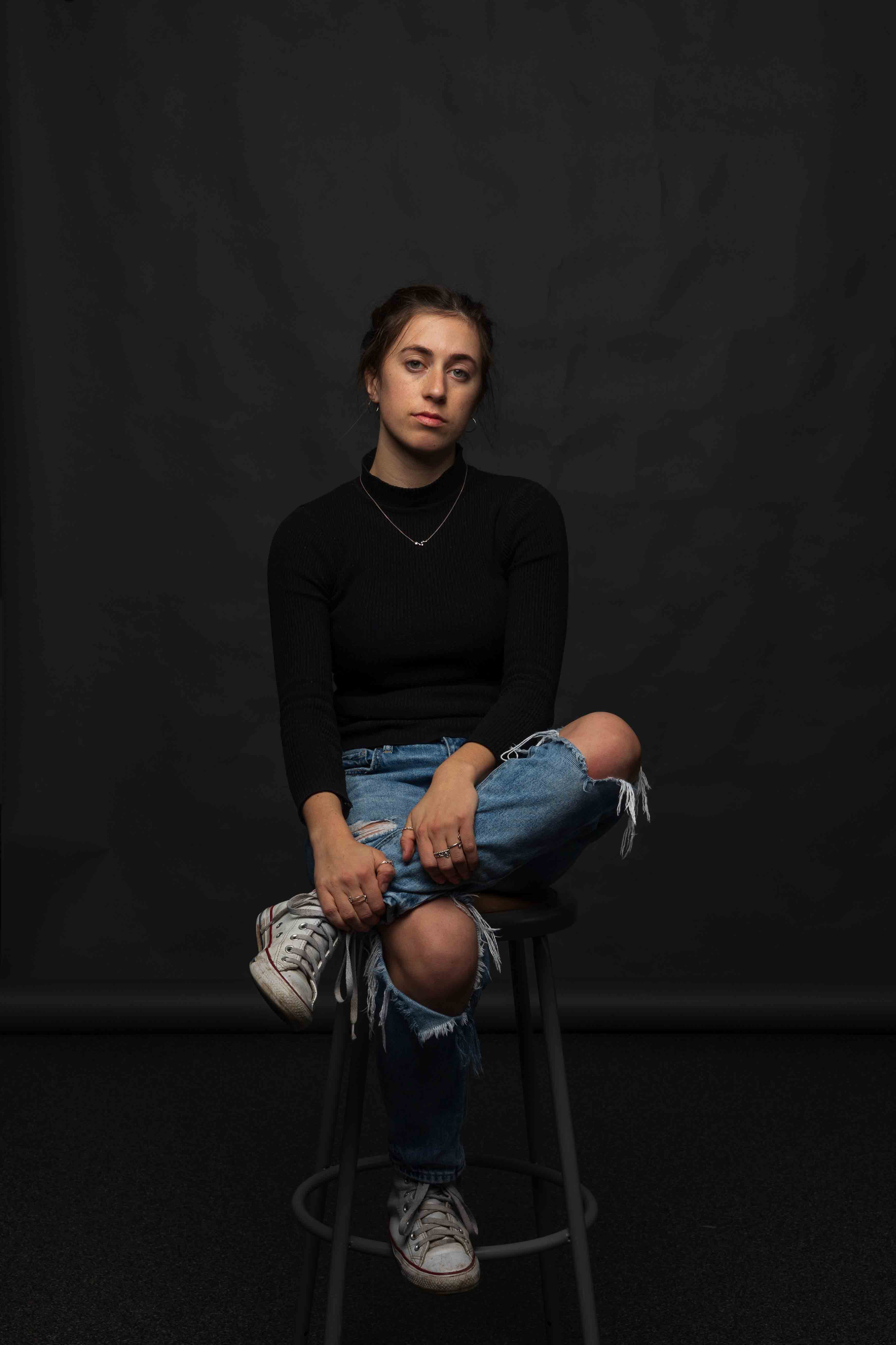 Ciara Stuhler '22 sits on a stool