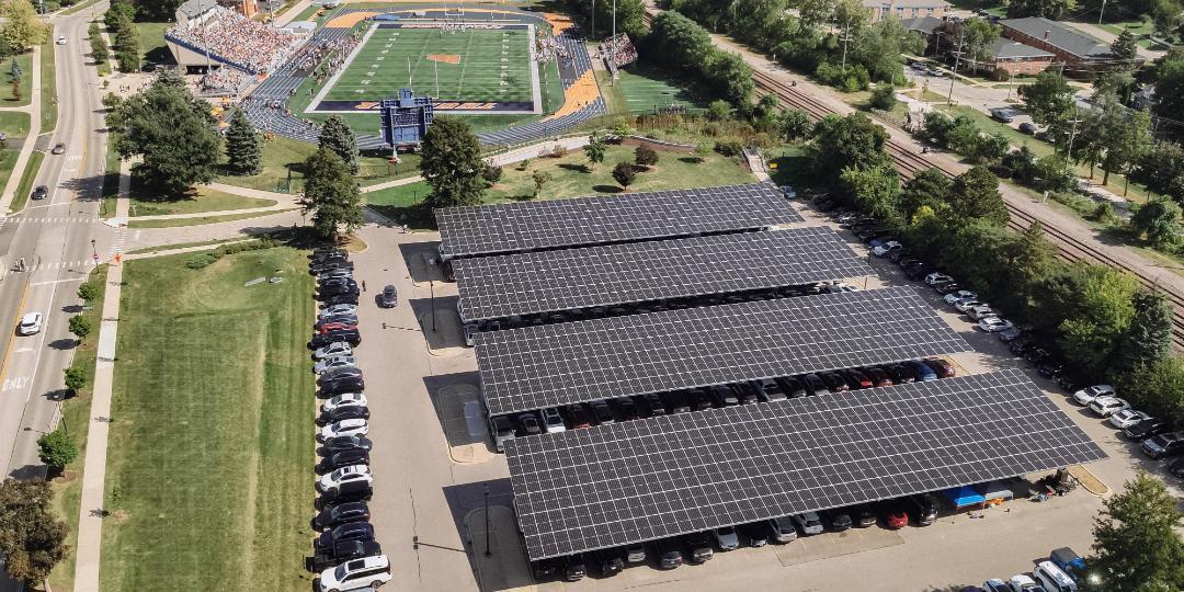 Overhead drone view of completed solar panels in Wheaton parking lot next to football field