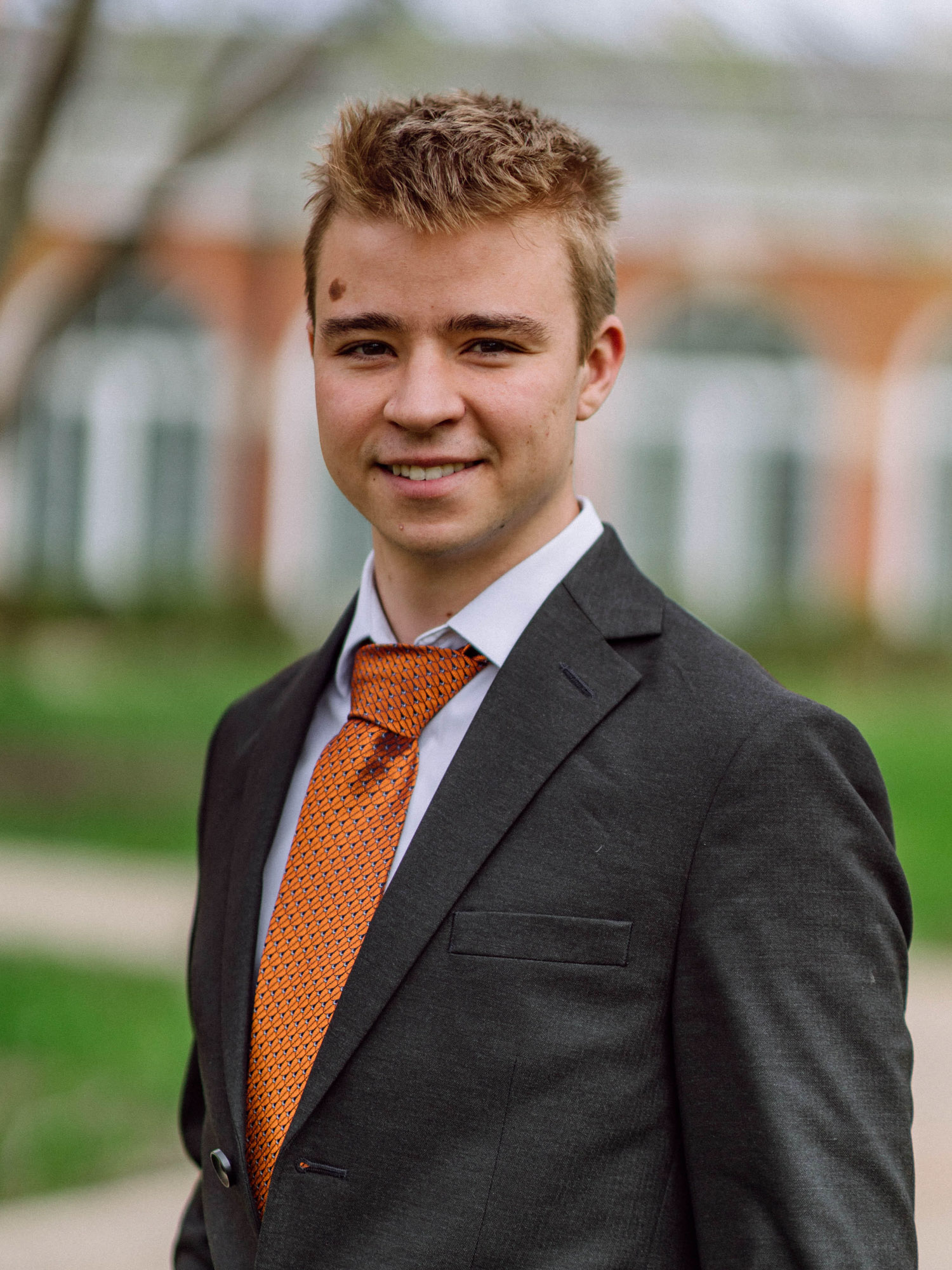 A young white male with light brown hair smiles