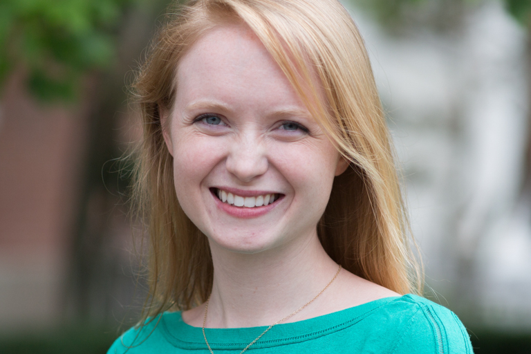 A white woman with strawberry blonde hair smiles