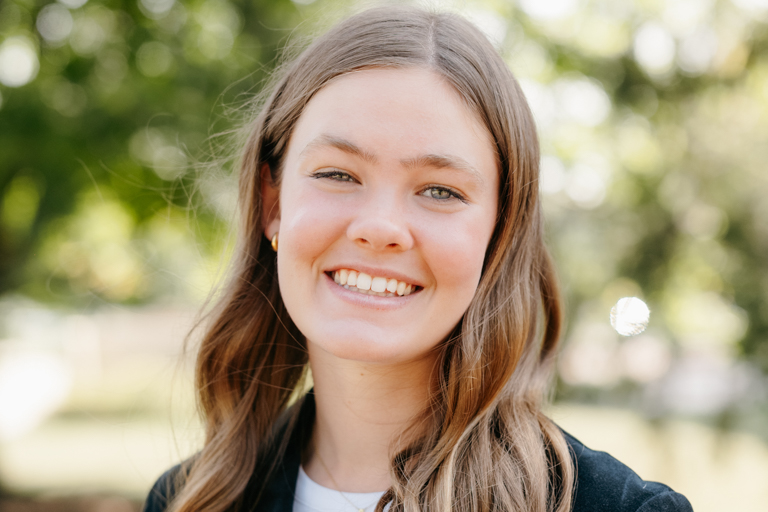 A blonde young woman smiles