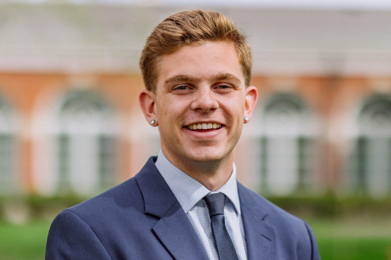 A young white male with blonde hair smiles