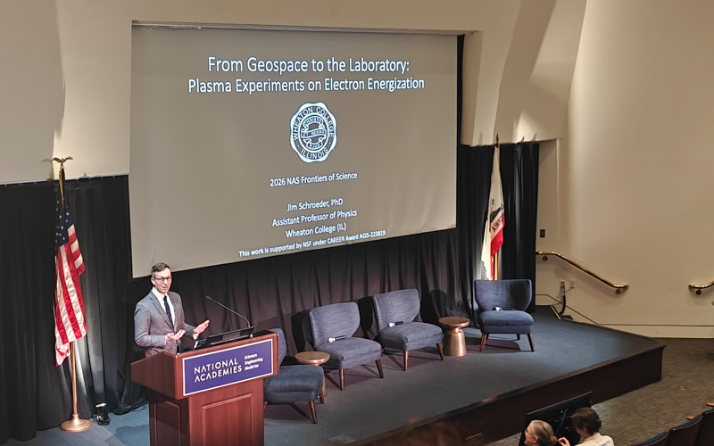 A white man speaks to an audience from a stage