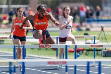 Wheaton College Women's Track Athlete Favor Ezewuzie jumping a hurdle