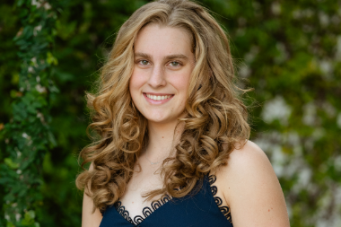 A blonde white young woman smiles